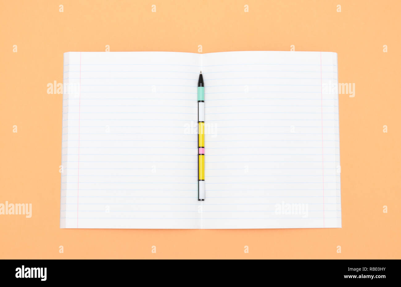 Notebook, pen and colored numbers on orange background. Accessories for ...