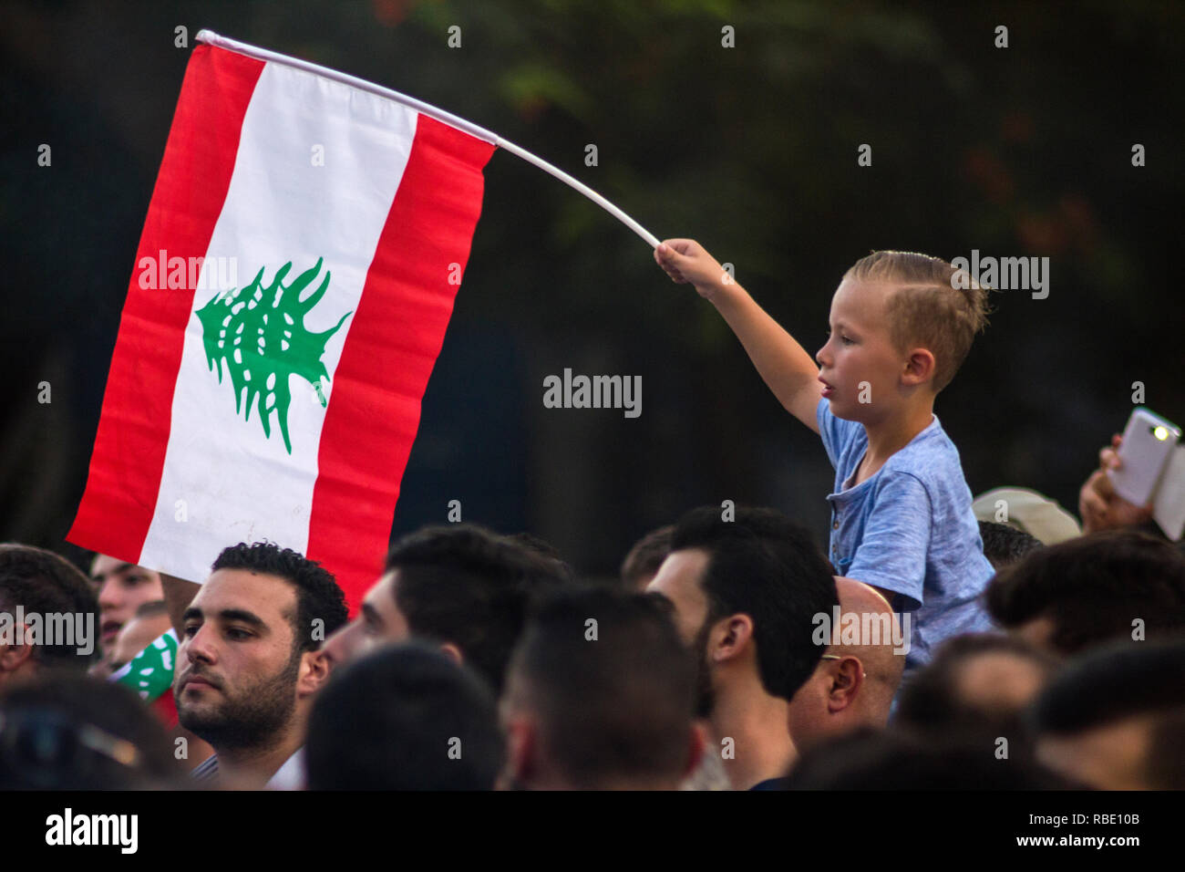 Beirut, Lebanon - August 29, 2015: A boy with the flag of Lebanon on a protest against trash crisis. Arabic spring protest in Beirut, Lebanon Stock Photo
