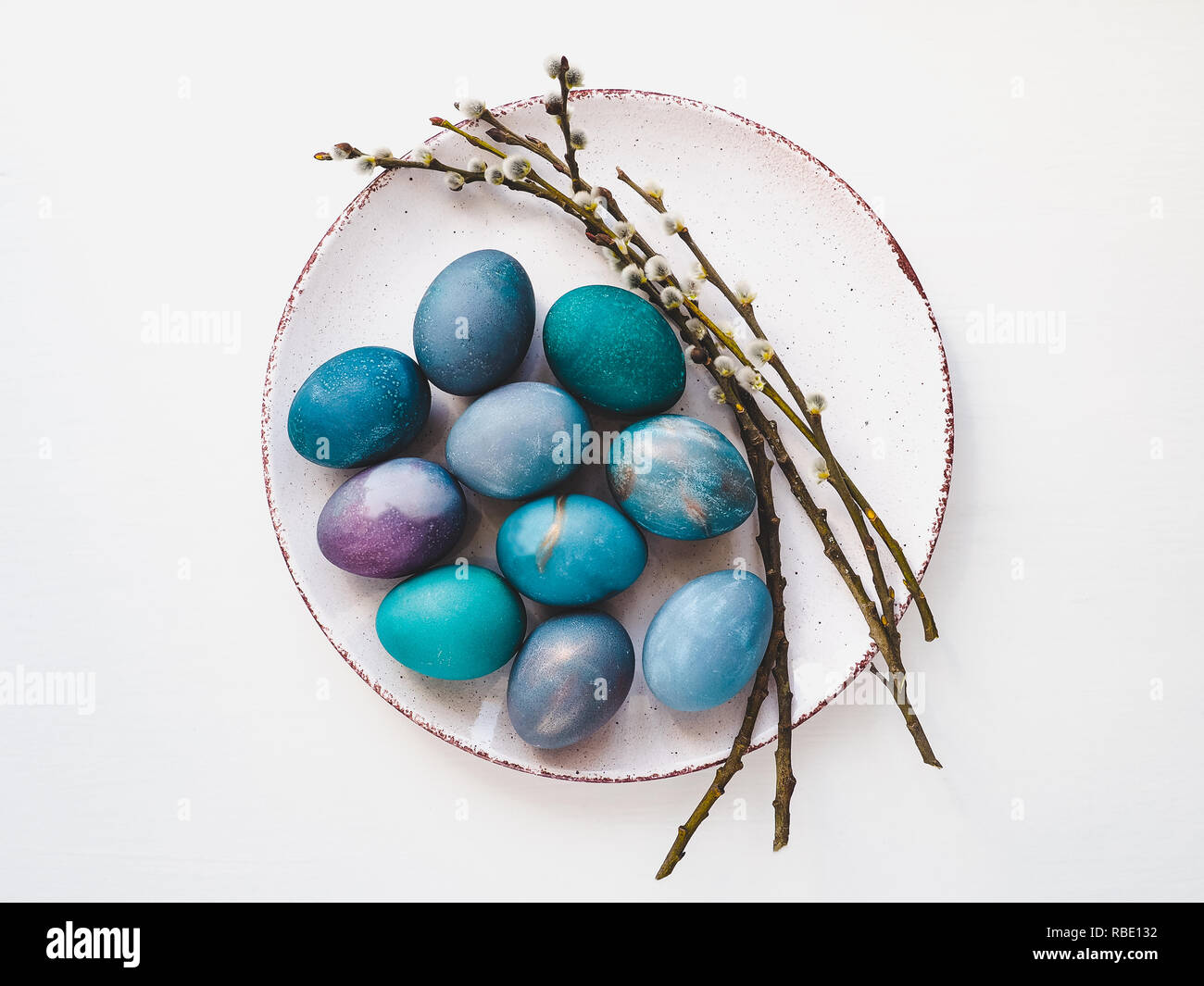 Multi-colored Easter eggs, twigs willows and old plate Stock Photo