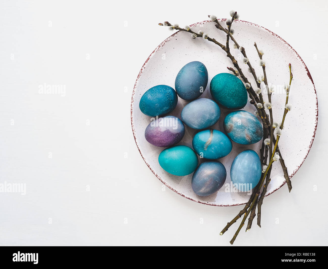 Multi-colored Easter eggs, twigs willows and old plate Stock Photo