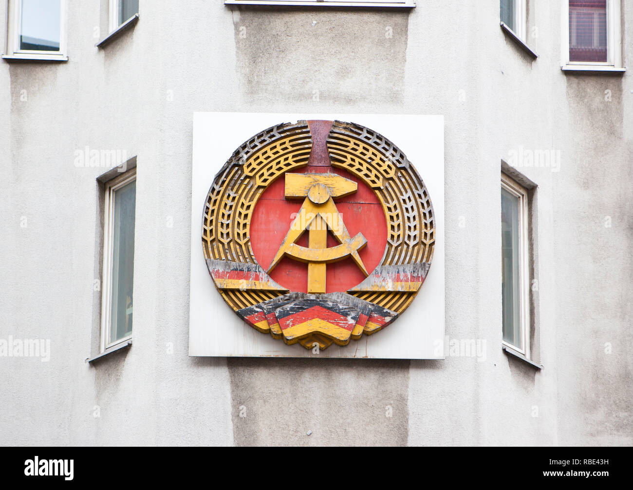 Emblem of the former German Democratic Republic with the communist symbols od hammer and sickle and spikes around. Stock Photo