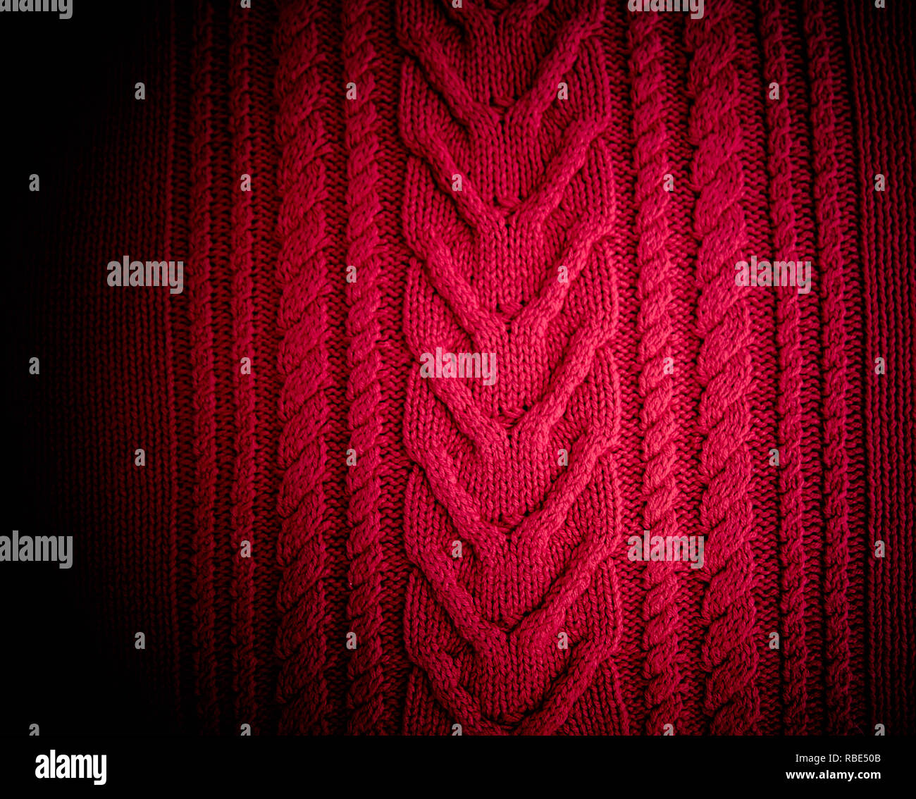 Red Knitted pattern wool sweater texture close up. Handmade red knitting wool texture background Stock Photo