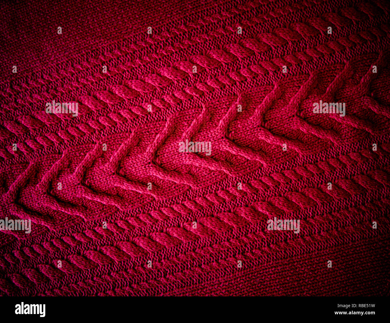 Red Knitted pattern wool sweater texture close up. Handmade red knitting wool texture background Stock Photo