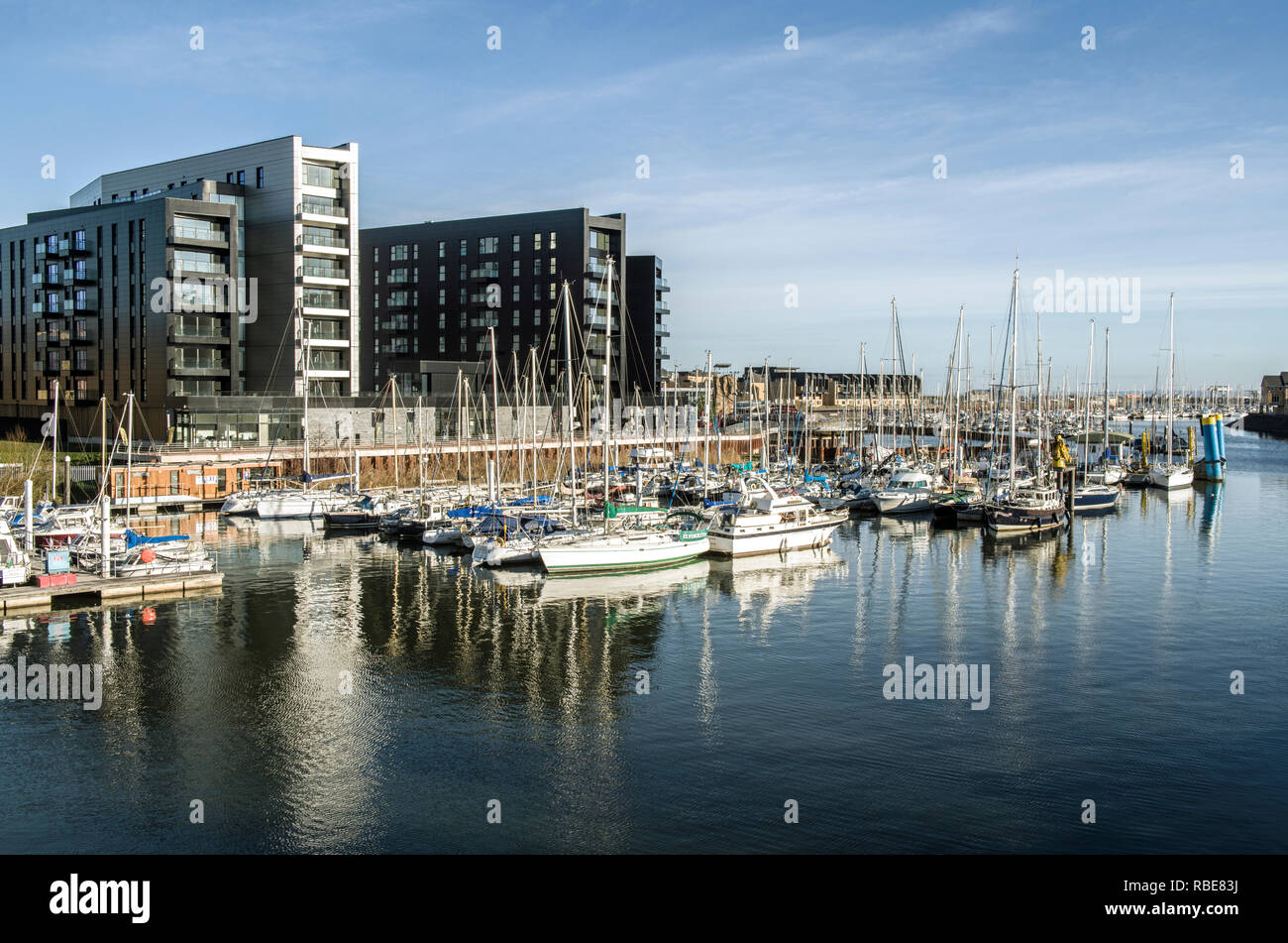 The River Ely coming into Cardiff Bay lined with apartments and full of leisure craft in the newly built marinas, South Wales Stock Photo