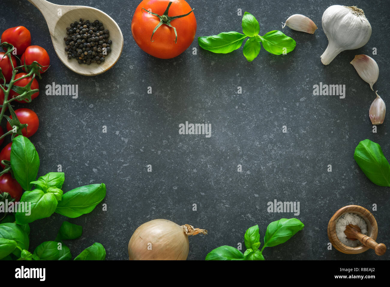 Italian food ingredients. Herbs and seasoning spices on dark stone background. Copy space Stock Photo