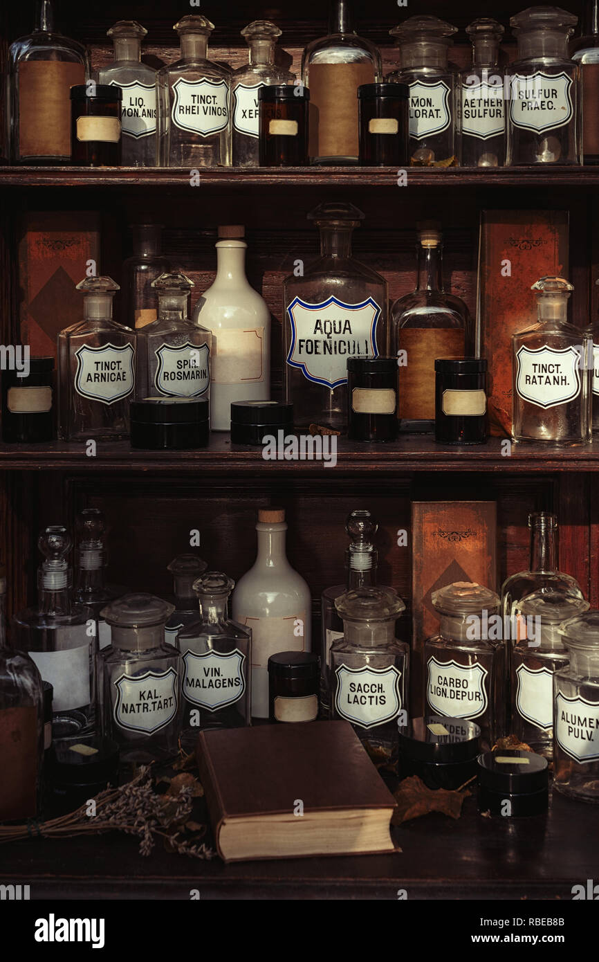 Wooden shelves with old bottles in an old retro apothecary shop Stock Photo