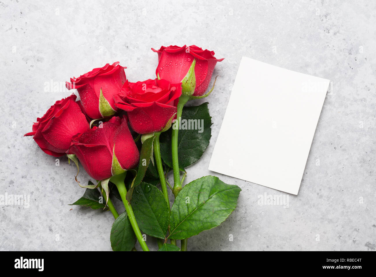 Valentine's day greeting card with red rose flowers bouquet on stone ...