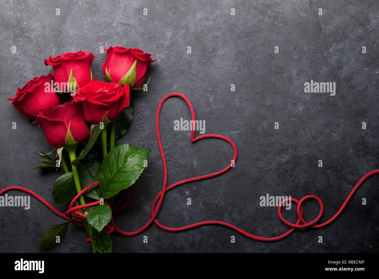 Valentine's day greeting card with red rose flowers bouquet on stone ...