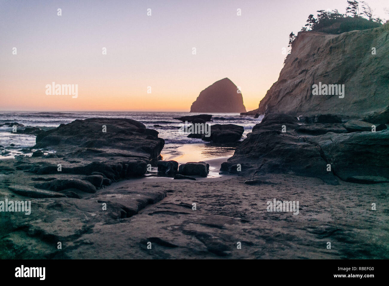 large rock at beach during sunset Stock Photo - Alamy