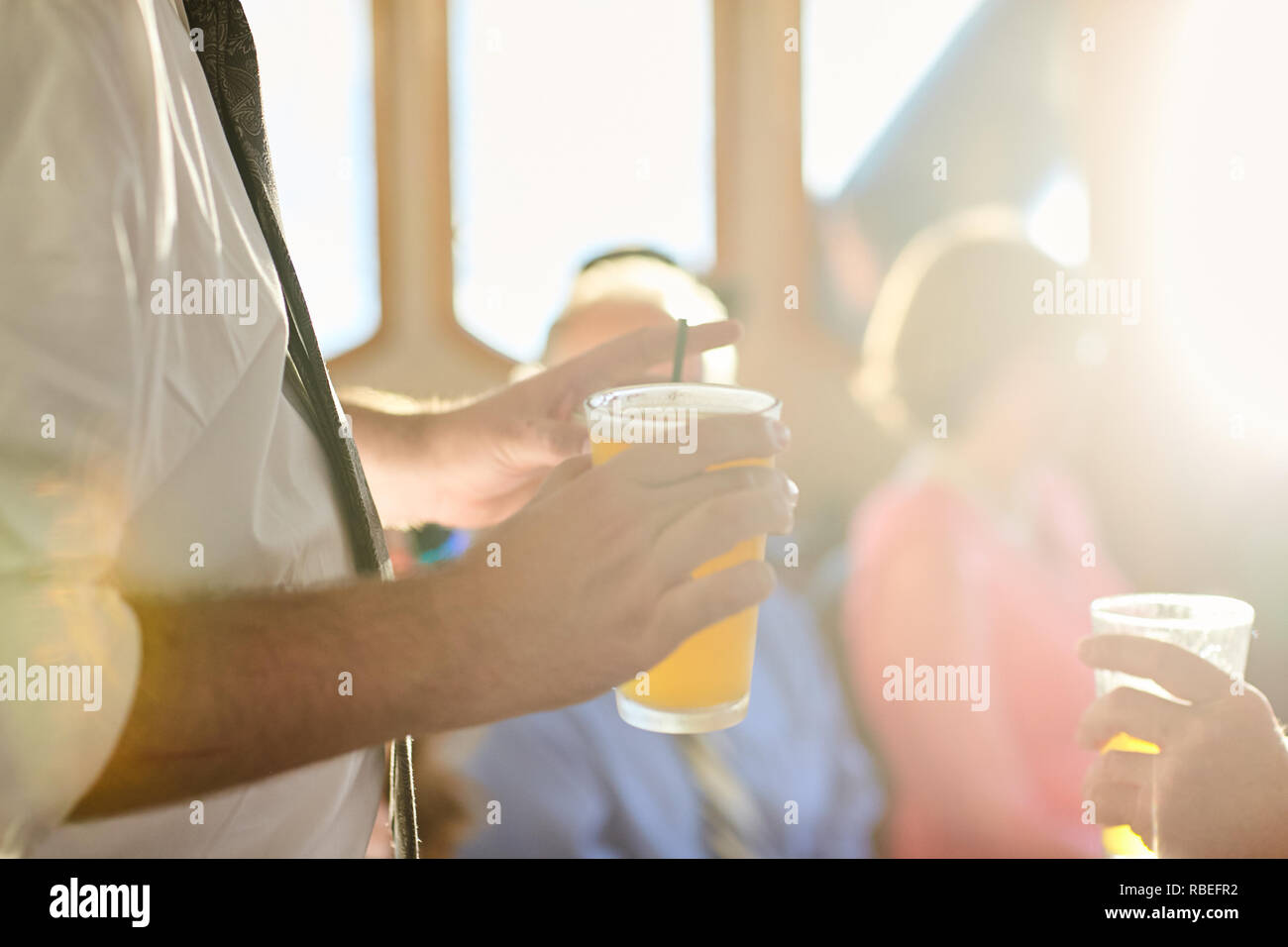 man holding a beverage at sunset Stock Photo - Alamy
