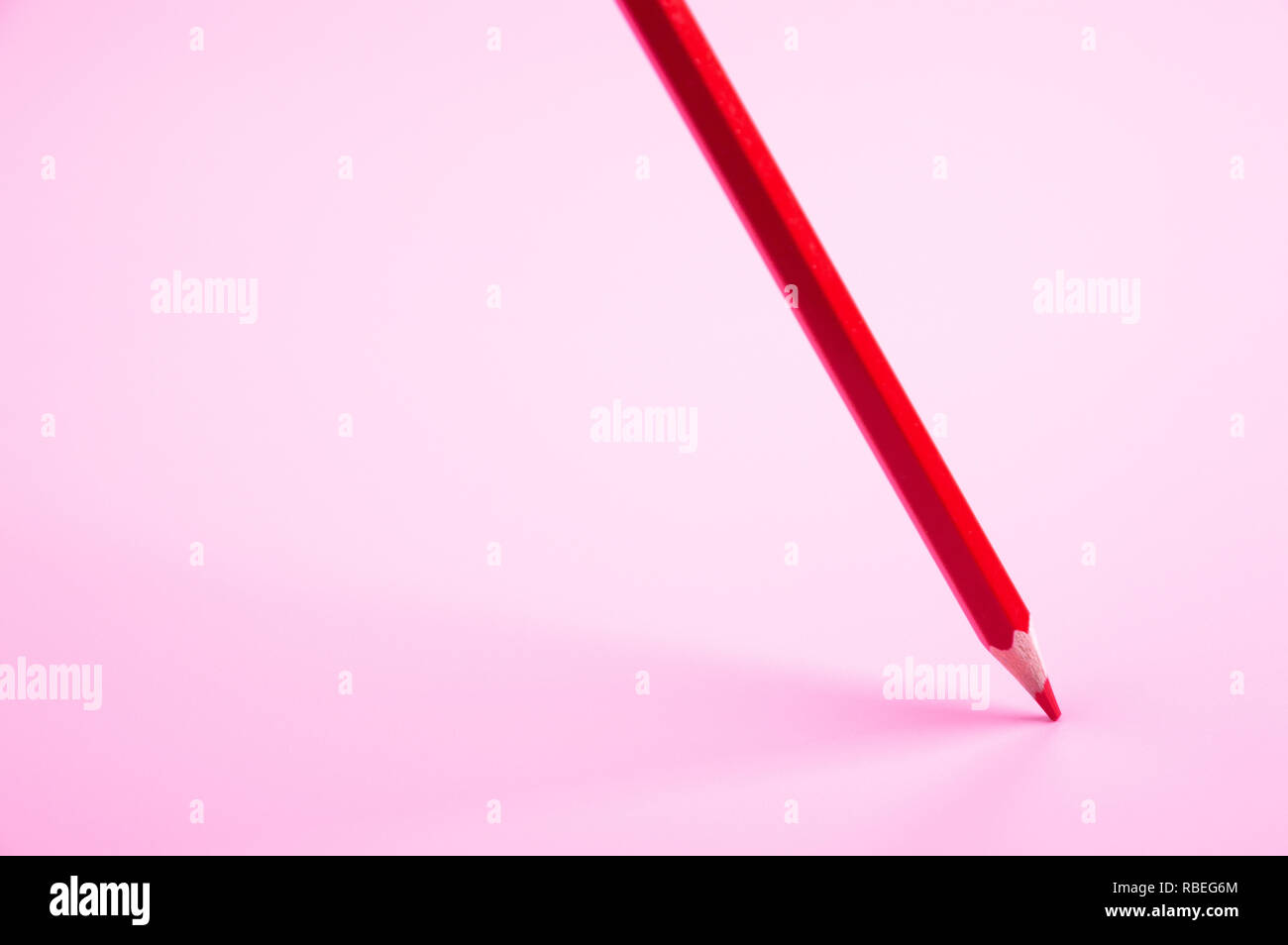 red pencil Floating on red background Stock Photo
