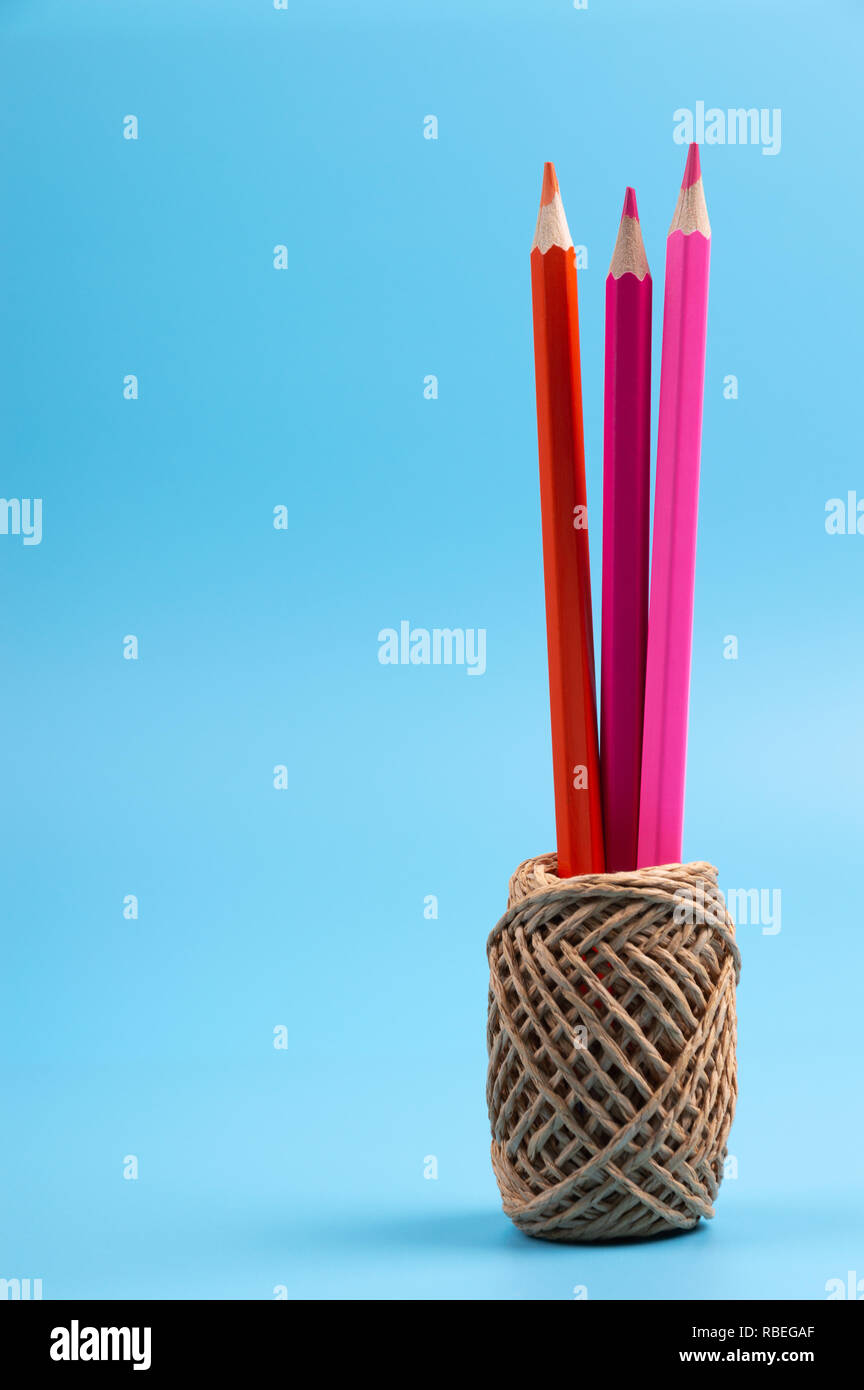 color pencils and string basket on blue background Stock Photo - Alamy
