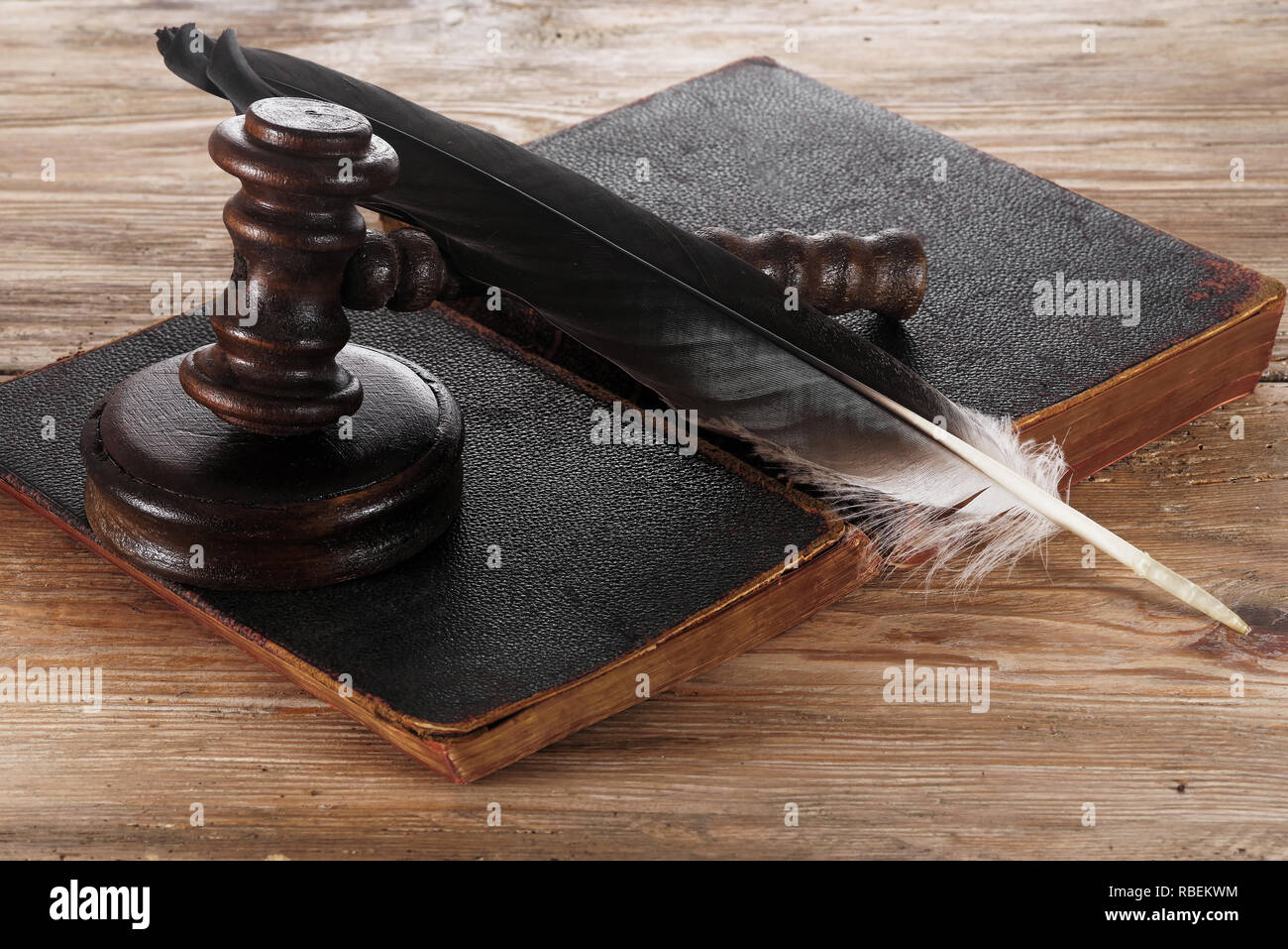 Law gavel or judge mallet and feather pen on a wooden desk Stock Photo