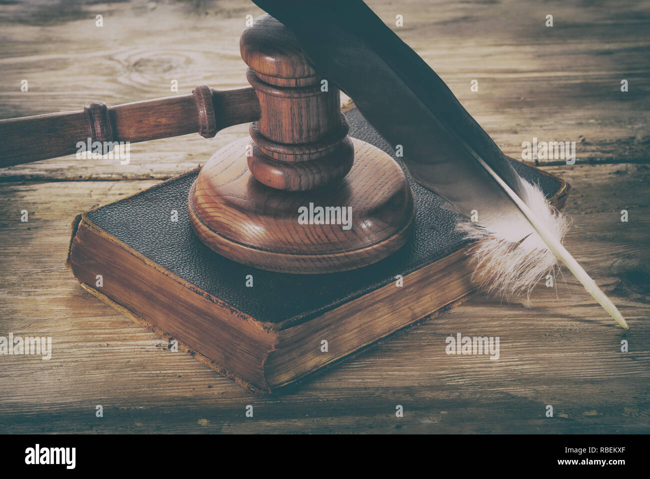 Law gavel or judge mallet and feather pen on a wooden desk Stock Photo