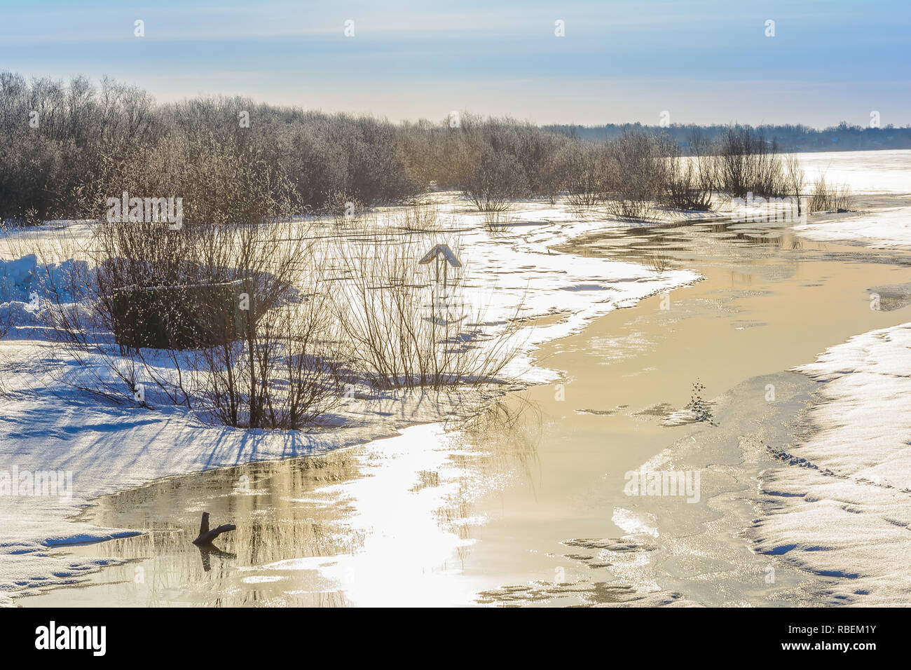 The river beach is flooded in the spring with melted snow and ice Stock Photo
