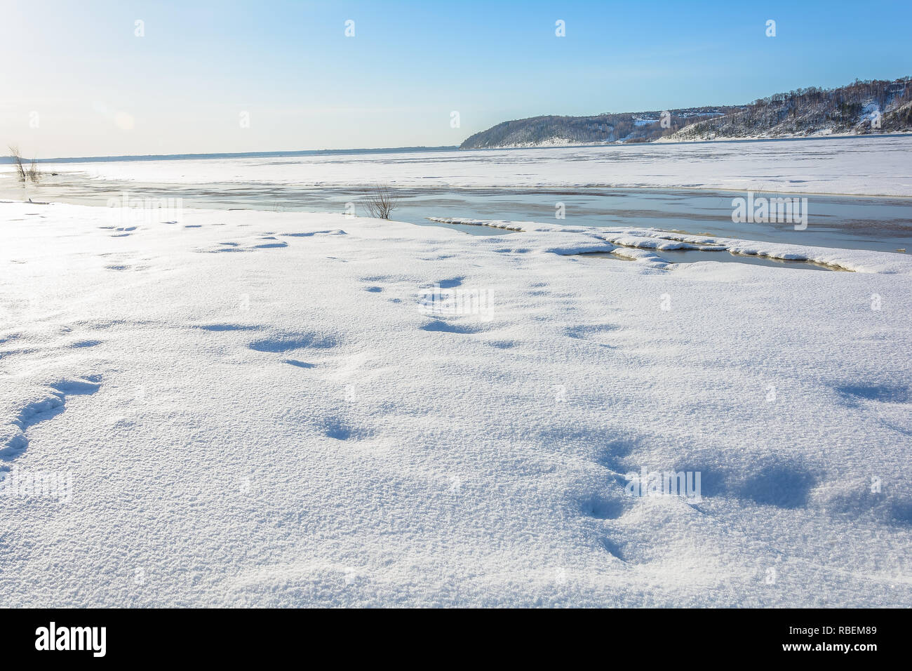 The river beach is flooded in the spring with melted snow and ice Stock Photo