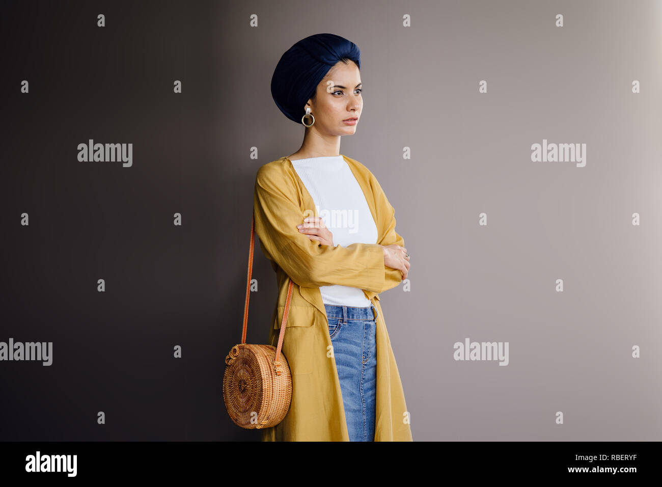 Studio portrait of a young, elegant and beautiful Middle Eastern woman in a turban hijab headscarf and stylish pastel-themed clothing. Stock Photo
