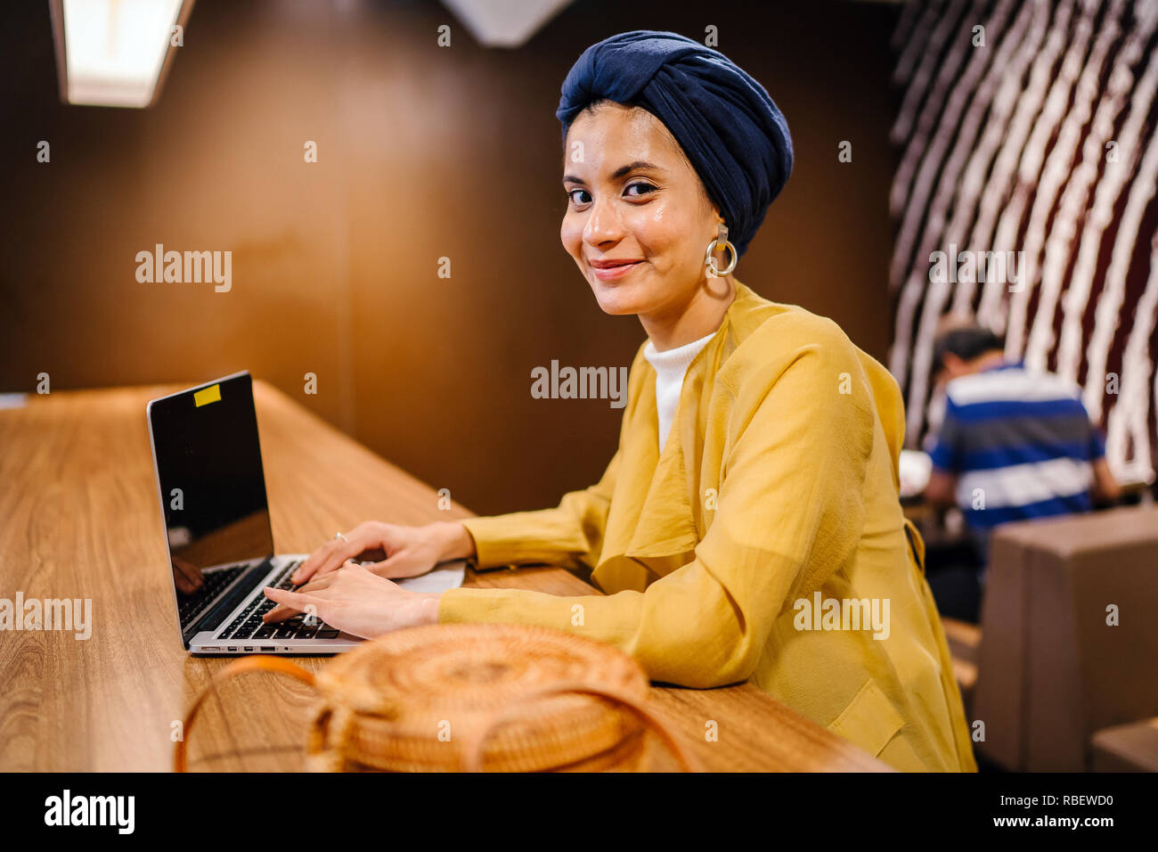 A young Malay Asian woman is typing and working or studying on her ...