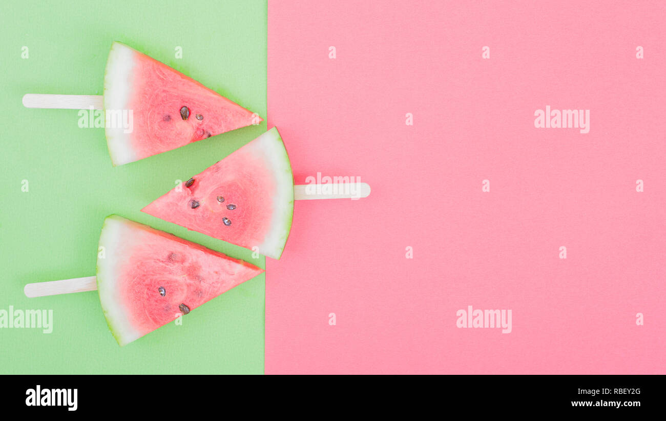 watermelon slice on green and pink background with stick Stock Photo