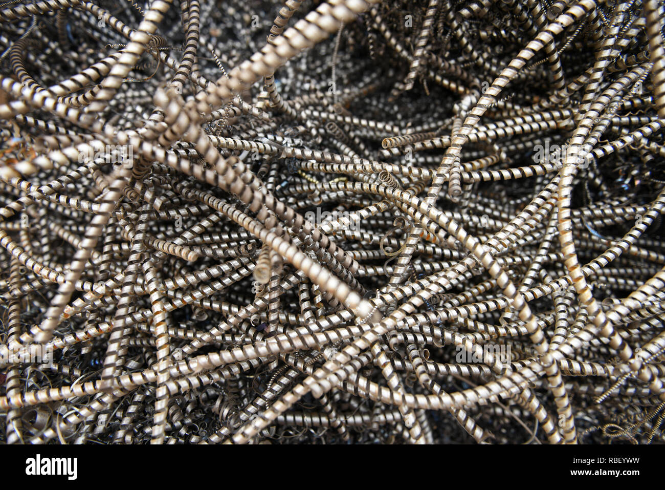Tangled twisted pile of discarded industrial scrap metal waste, spiral ...