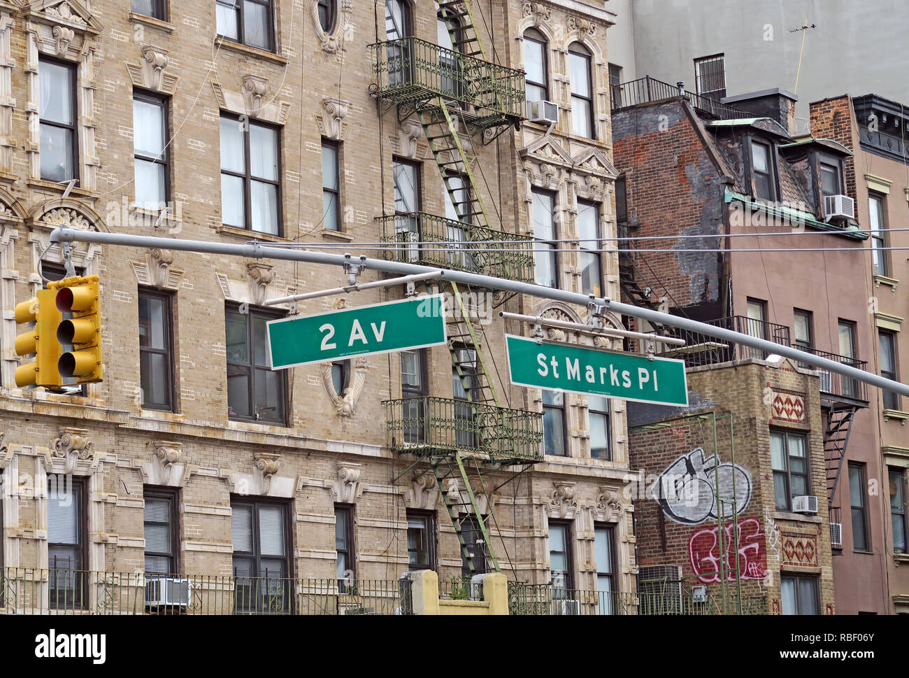 Street signs for hobo & hip St Marks Place and Second Avenue amid historic tenements and fire escapes in Manhattan's East Village, New York City. Stock Photo