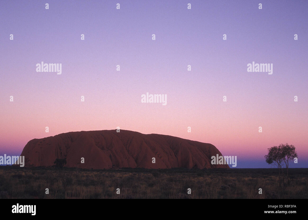 Uluru also known as Ayers Rock and officially gazetted as 'Uluru / Ayers Rock' is a large sandstone rock formation in the southern part of the NT. Stock Photo