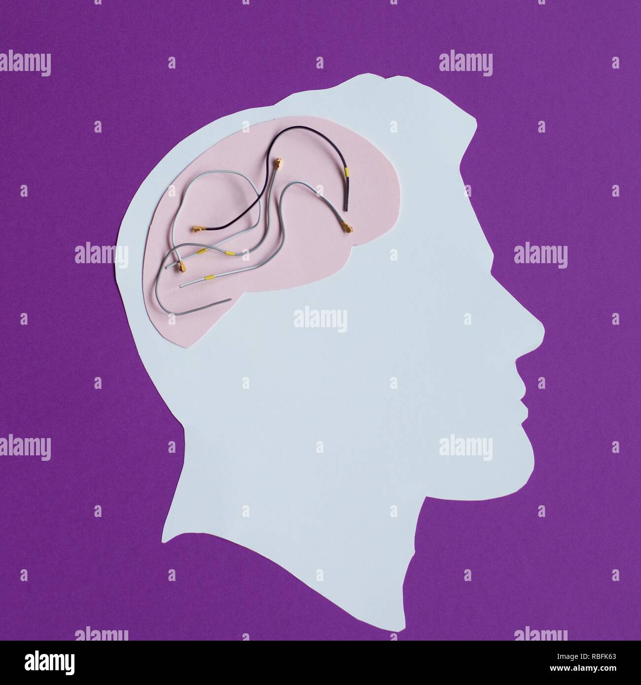 Cut paper and wires to represent the brain and technology. Stock Photo
