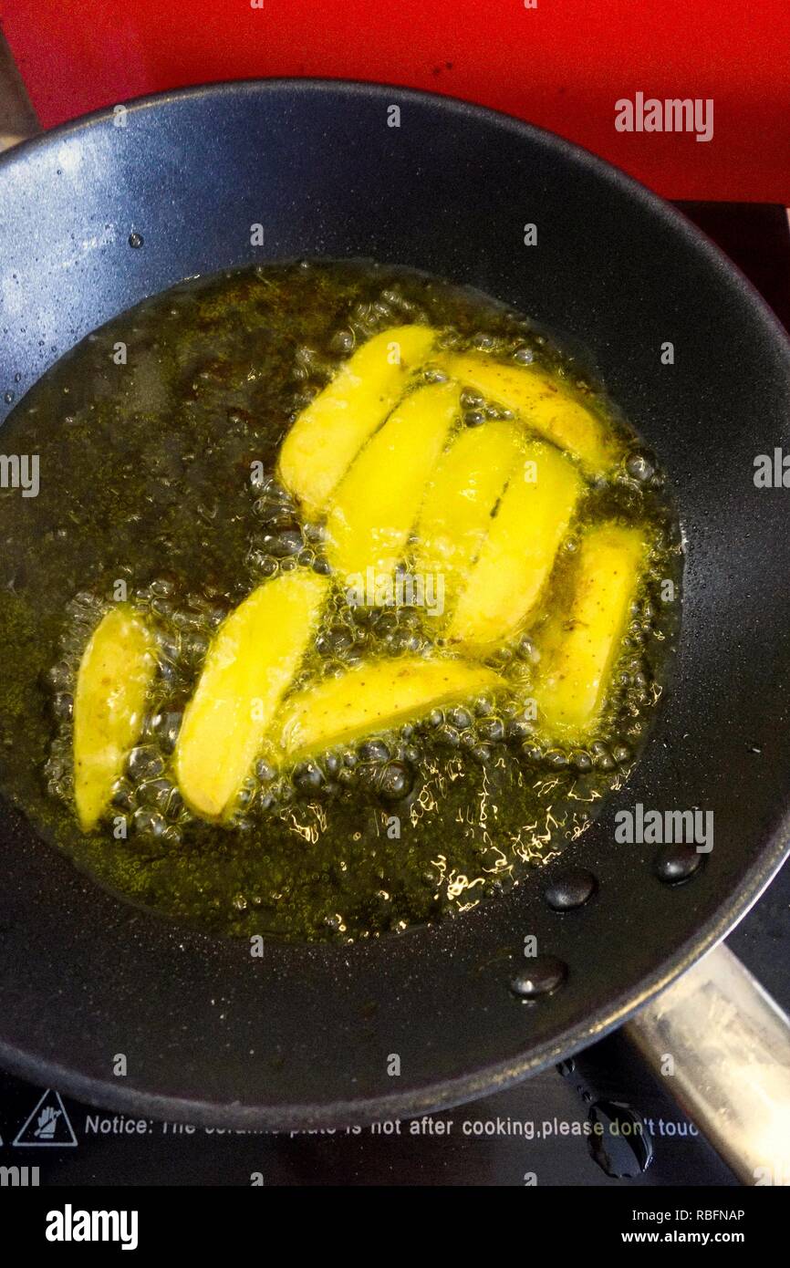 Frying Homemade Potato Chips on an Iduction Hotplate Stock Photo
