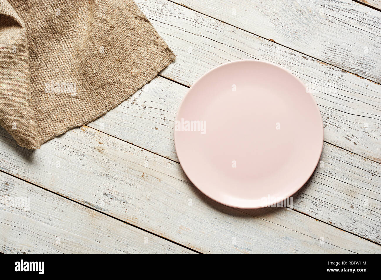 Empty plate and towel over wooden table background. Stock Photo