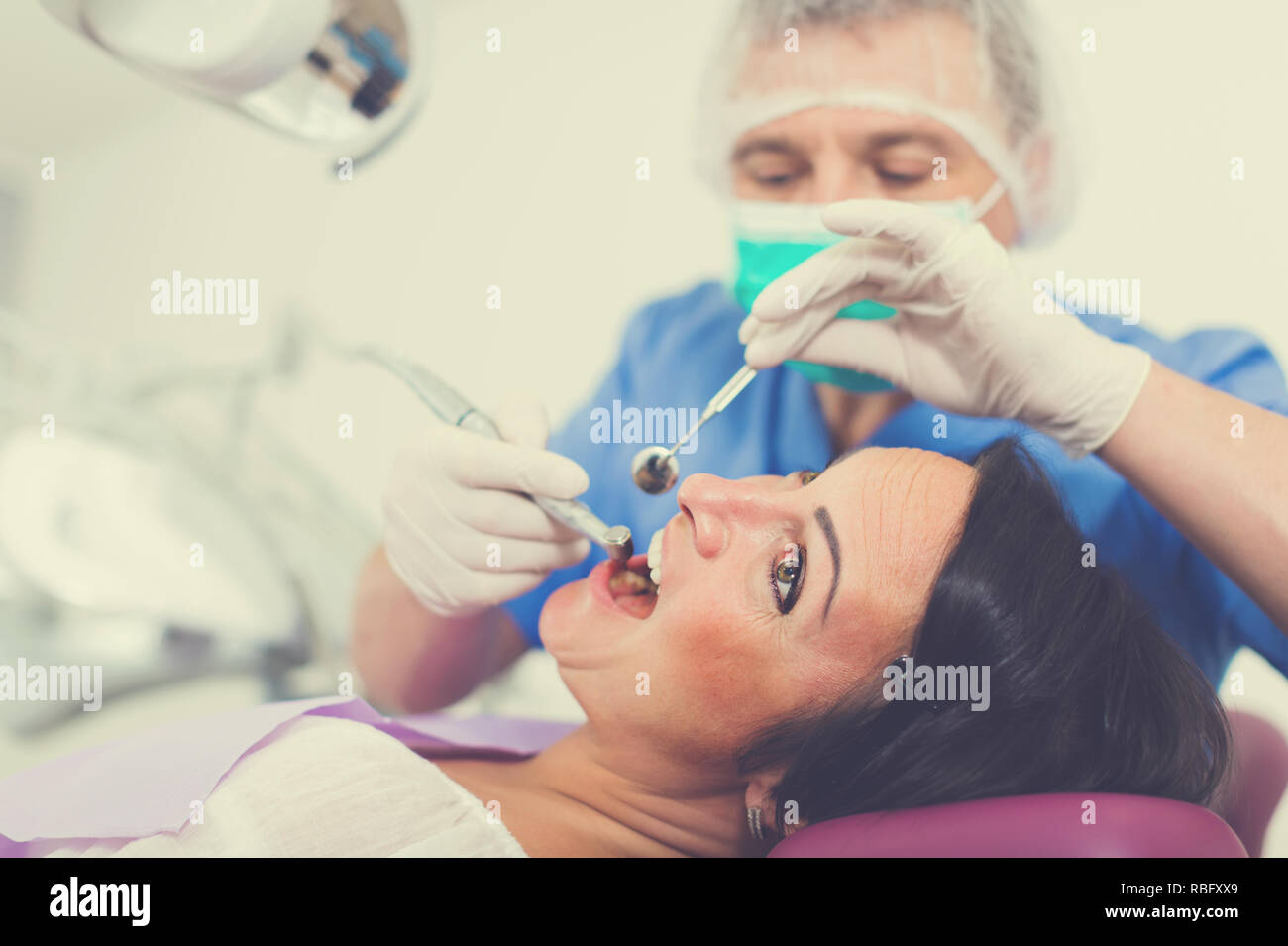 dentist professional filling teeth woman patient sitting in medical