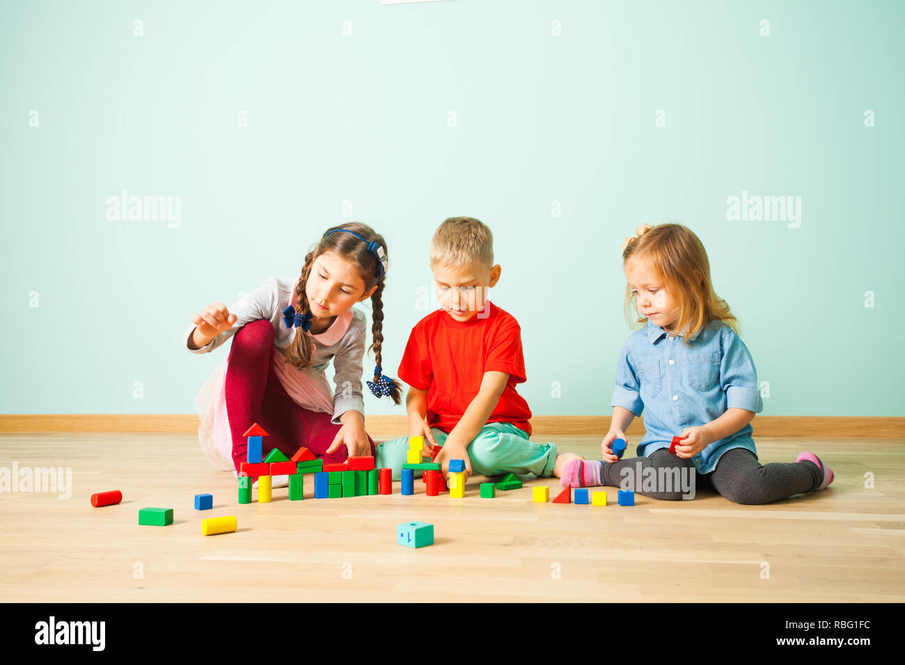 Preschoolers playing together creating from the wooden blocks. Children