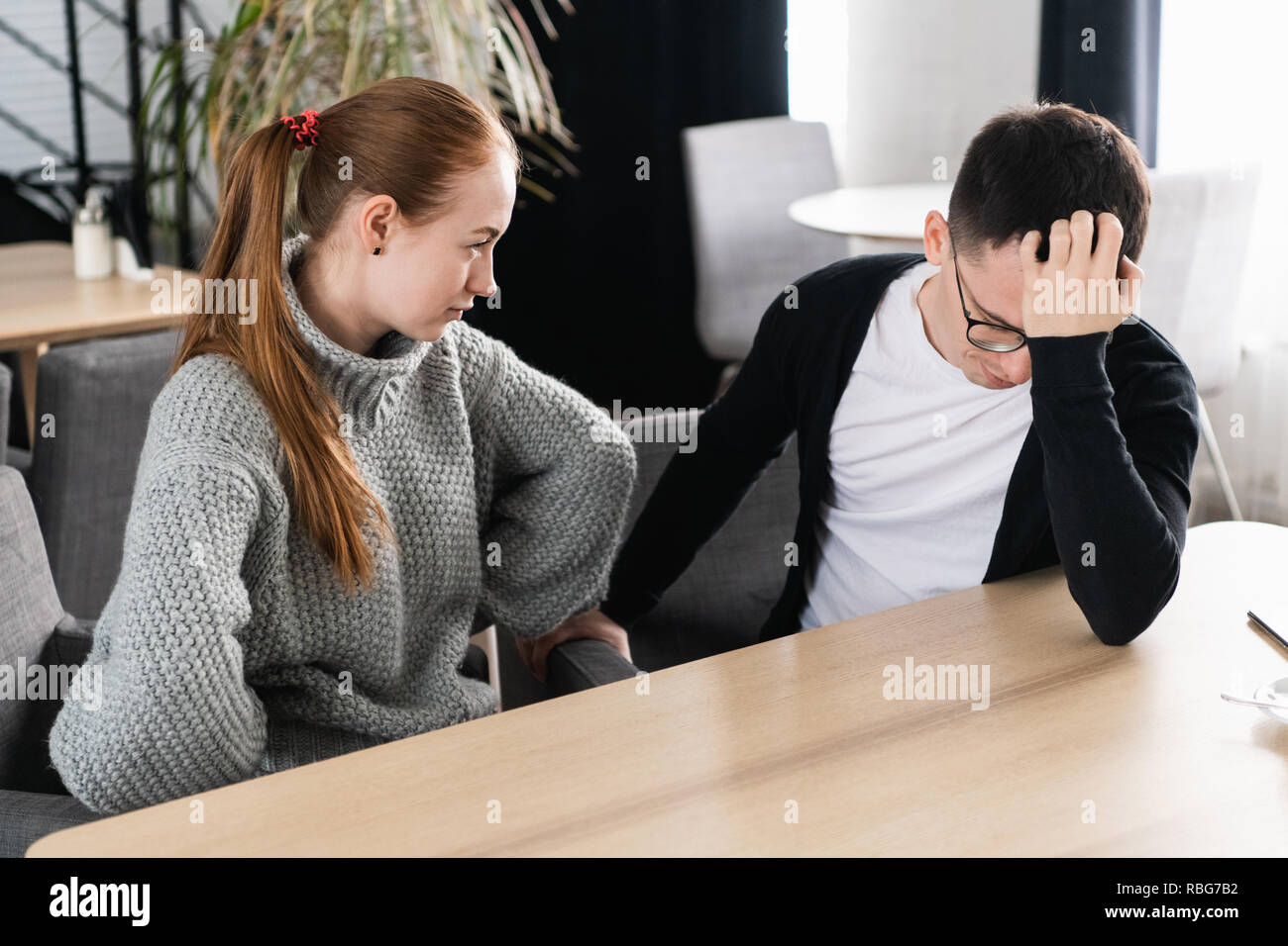 Unhappy young couple arguing, angry wife looking at husband blaming him of problems, conflicts in marriage, bad relationships, man and woman having quarrel or disagreement Stock Photo