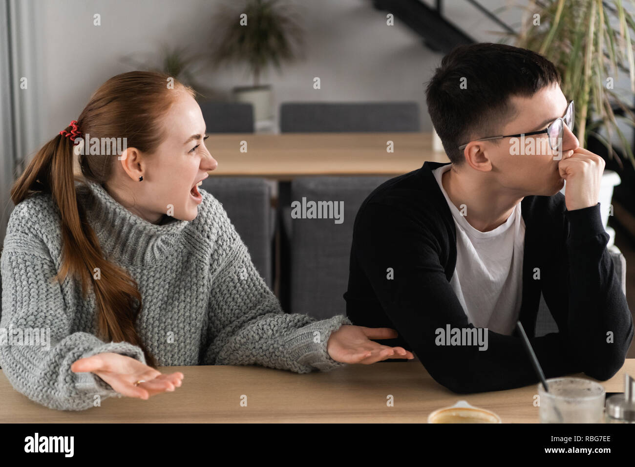 Young woman yelling at boyfriend in hysterics, drama queen screaming loud shouting at husband trying to get attention, having a tantrum, lack of emotional intelligence, manipulation in relationships Stock Photo