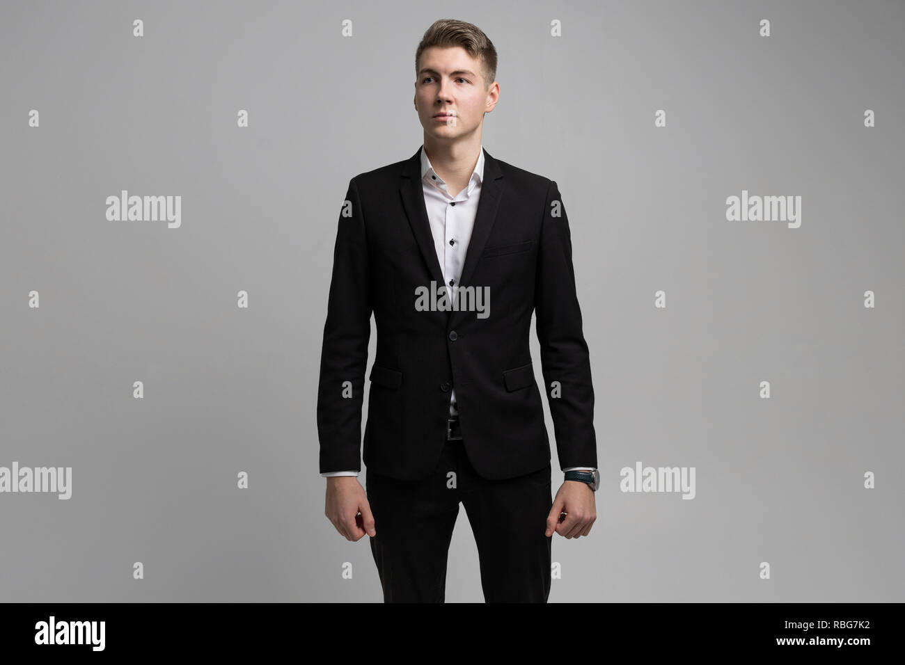 Portrait of young man in black suit isolated on white background Stock ...