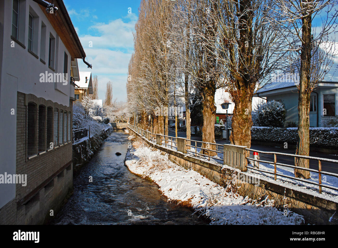 Alley next to the Lyssbach river, a small brook passing the city center of Lyss, Switzerland. Winter photo. Stock Photo
