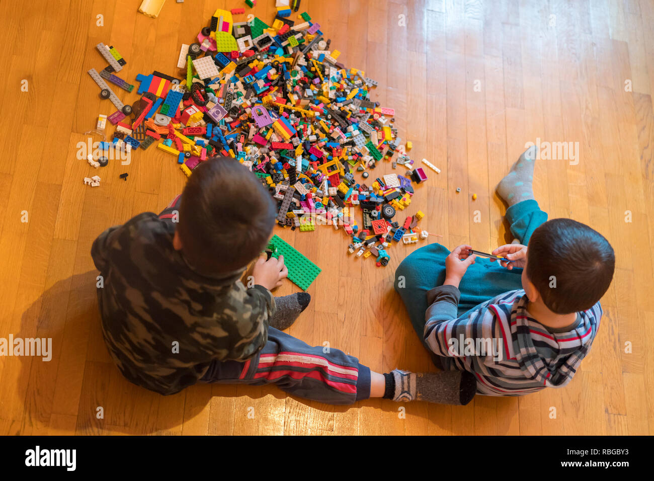 Two children playing with lots of colorful plastic blocks constructor ...