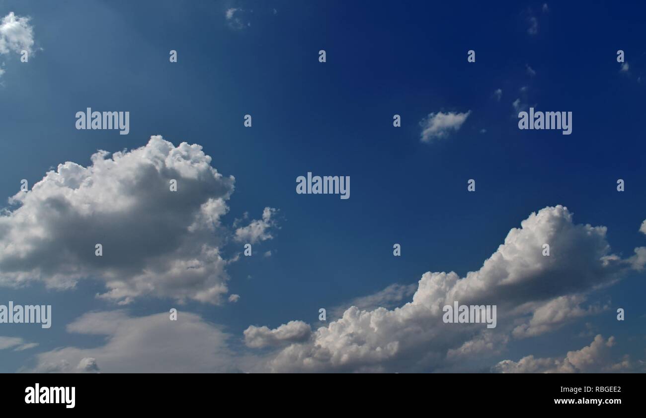 Fluffy white clouds in a blue summer sky Stock Photo - Alamy