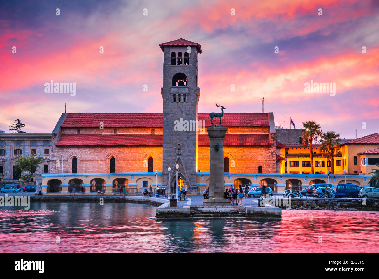 Rhodes, Greece. Stunning sunset image Mandraki harbour and Evaggelismos Church the place of Colossus of Rhodes. Stock Photo