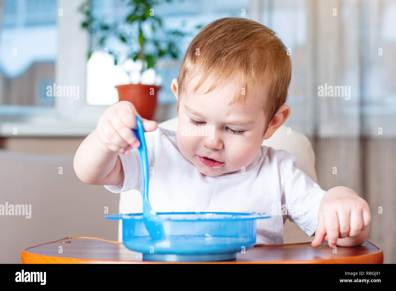 when should a baby feed itself with a spoon
