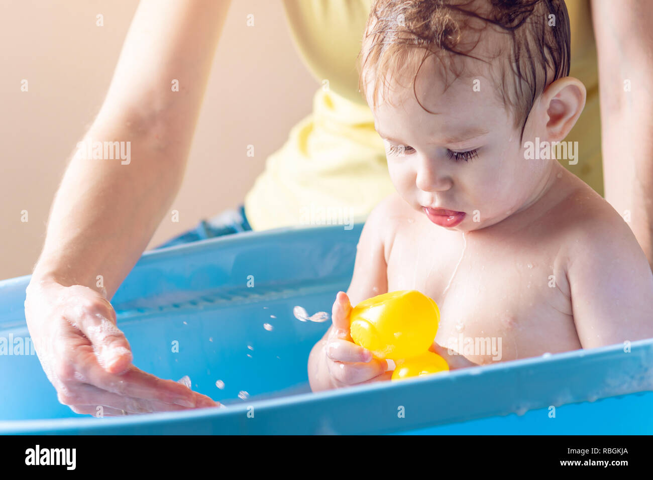 Mom Washing Little Boy In A Blue Bath The Child Is Playing With A Yellow Duck Hygiene And Water Treatment At Home With The Baby Stock Photo Alamy