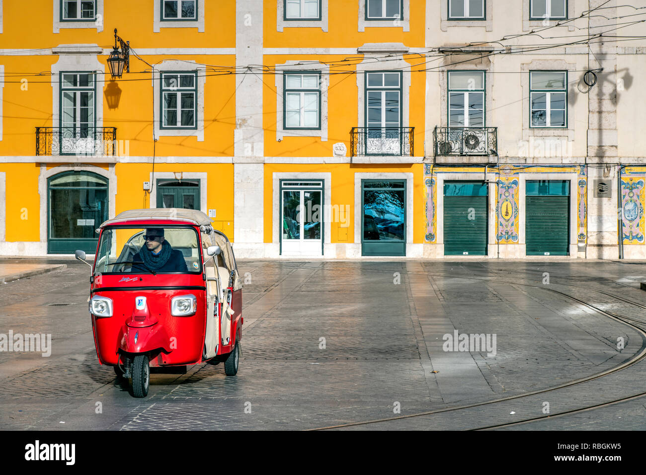 A three-wheel tuk tuk tourist taxi parked in a square of Baixa district, Lisbon, Portugal Stock Photo