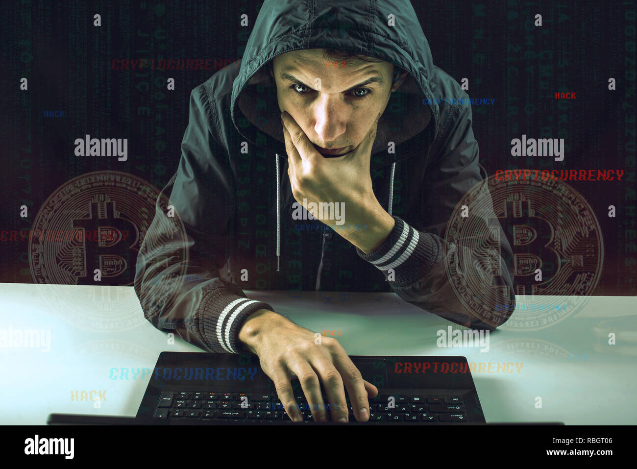 A hacker with a face is trying to steal cryptocurrency using a computer.  Scam at Cryptojacking Stock Photo - Alamy