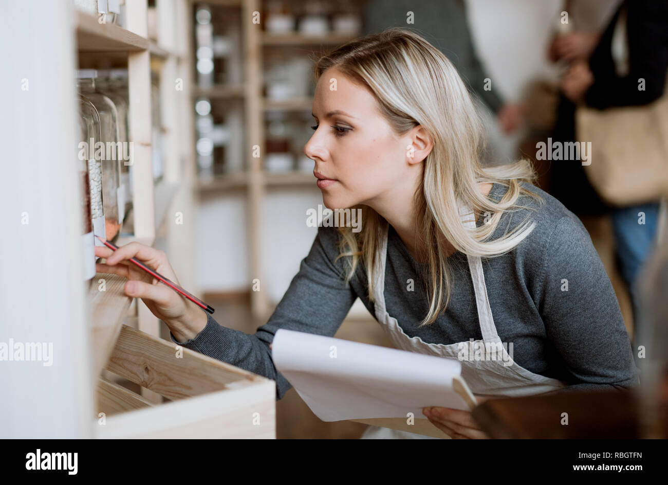 A female shop assistant working in a zero-waste shop. Stock Photo