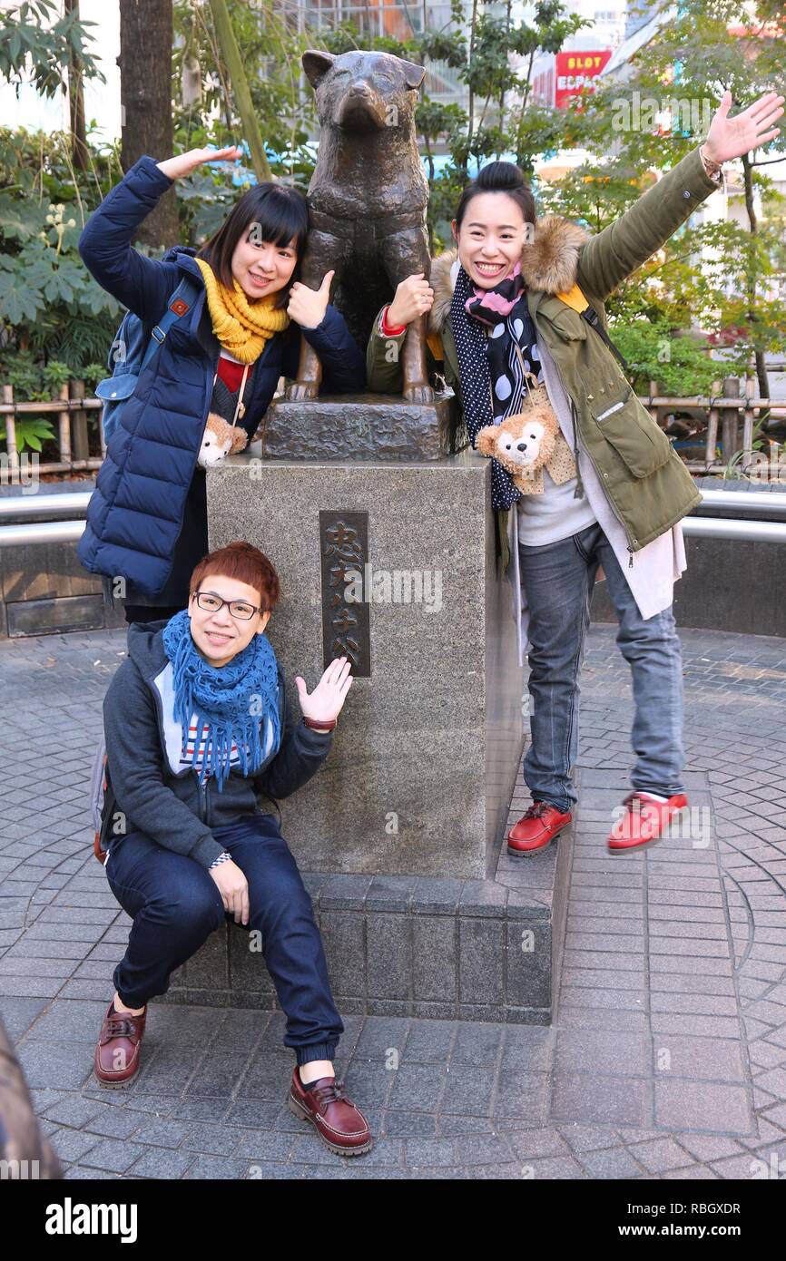 TOKYO, JAPAN - DECEMBER 3, 2016: People visit Hachiko dog statue in Shibuya, Tokyo. Hachiko was a famous dog who waited for owner after his death. Stock Photo