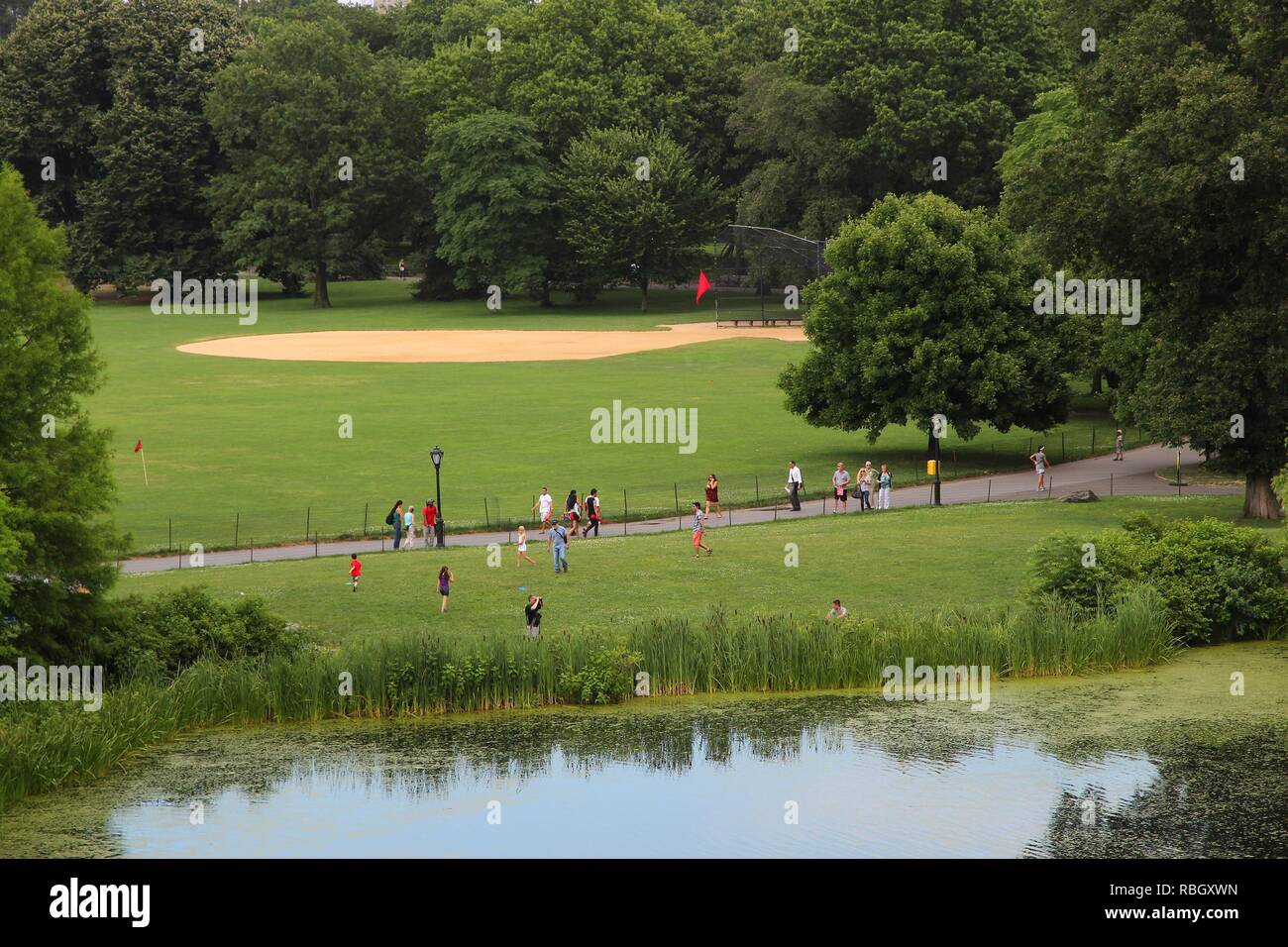 NEW YORK, USA - JULY 2, 2013: People visit Central Park in New York. Park opened in 1857 and covers 840 acres of land today. Stock Photo