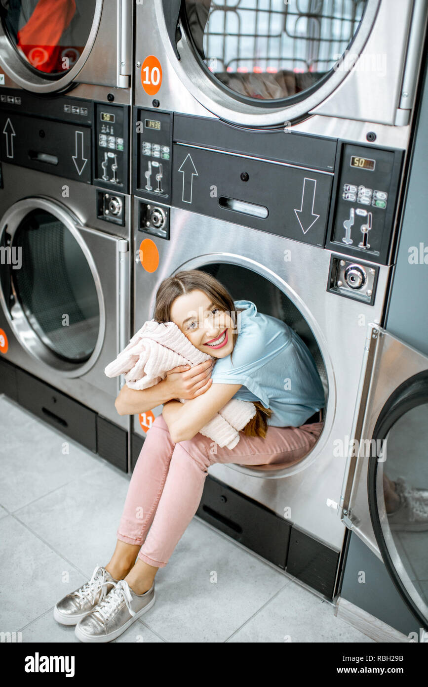Portrait of a cheerful woman with clean and fresh towels sitting on the