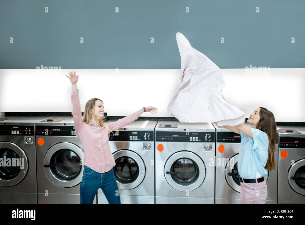 Young and playful women throwing up a towel making clothes after the