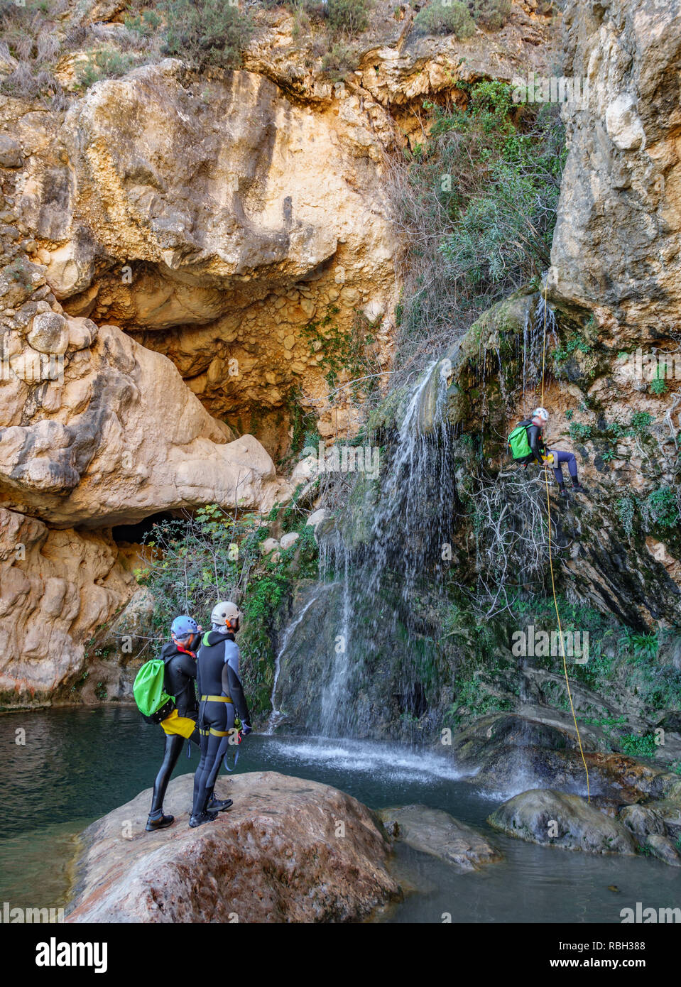 Three people practicing cayoning in the river canyon, vertical composition Stock Photo
