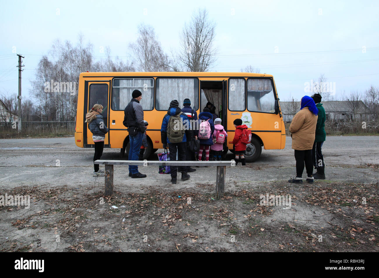 School children of Radinka entering the schoolbus in the early morning. Radinka, Polesskiy district, Kiev Oblast, northern Ukraine Stock Photo