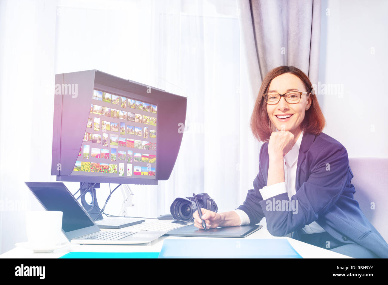 Happy woman working with graphic tablet in office Stock Photo